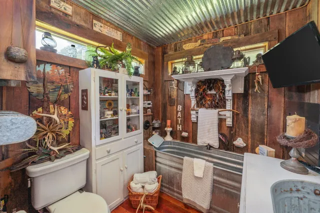 a view of a patio with table and chairs a barbeque with wooden floor and roof
