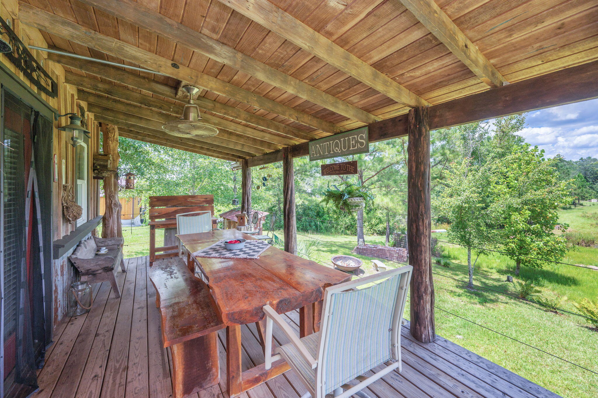 54 Wing Road Wing, AL 36483 - Photo 18 of 50 a view of a patio with table and chairs in front of a house with wooden floor