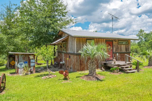 a view of a small yard in front of a house with wooden fence