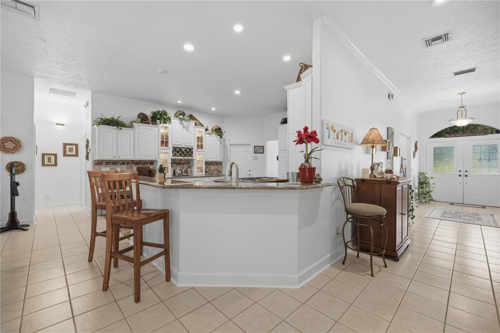 700 Southwest 89th Terrace Ocala, FL 34481 - Photo 17 of 94 a kitchen with stainless steel appliances kitchen island granite countertop a table and chairs in it