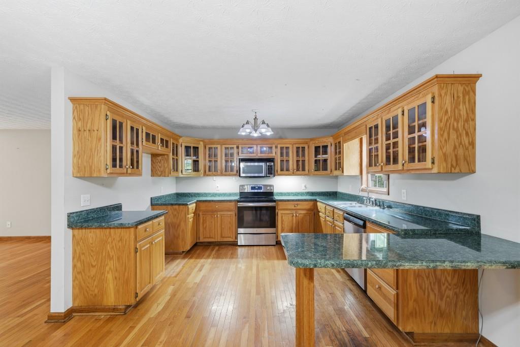 176 Big Oak Tree Road Northwest Adairsville, GA 30103 - Photo 15 of 77 a kitchen with stainless steel appliances granite countertop a stove and a wooden cabinets
