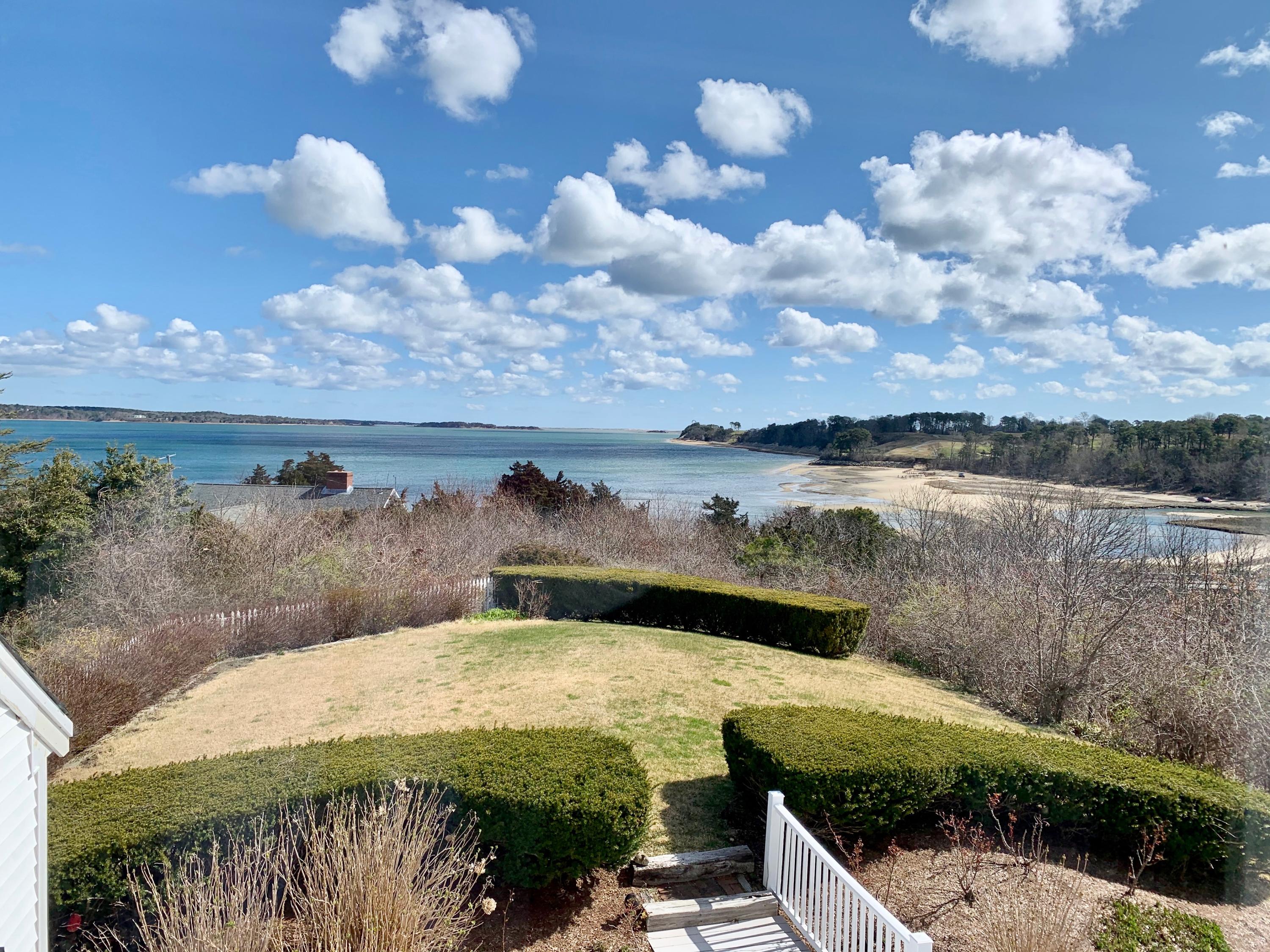 265 Bay Road Harwich, MA 02645 - Photo 19 of 38 a view of a lake with lawn chairs and wooden floor