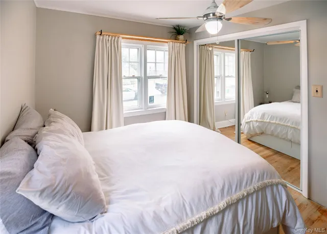 a large bed sitting in a bedroom next to a window and a chandelier