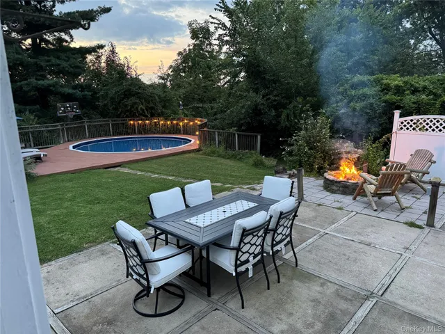 a view of a table and chairs in back yard of a house