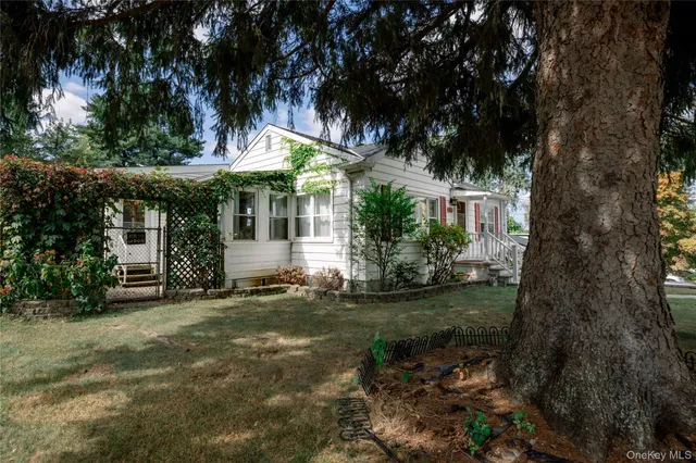 a view of a house with a tree in front of it