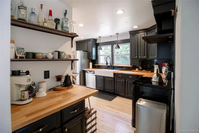 a kitchen with stainless steel appliances granite countertop a sink stove and cabinets
