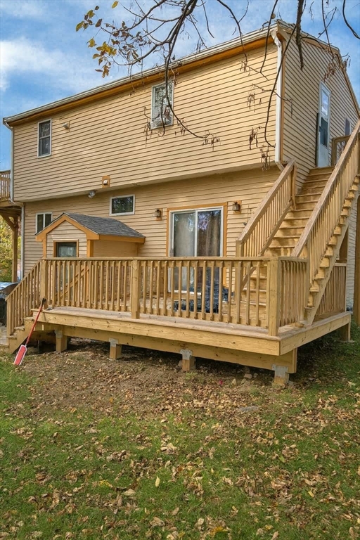 1042 Sassaquin Avenue, Unit 2 New Bedford, MA 02745 - Photo 1 of 13 a view of a house with a wooden deck and a small yard