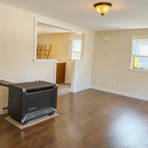 a living room with hard wood floors and a window
