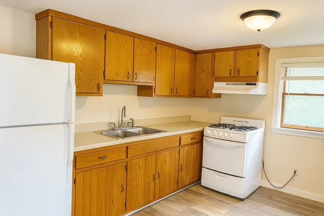 a kitchen with a sink a stove and white cabinets