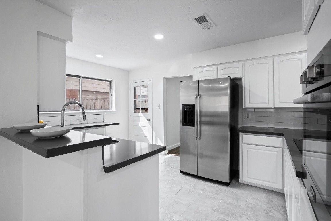 322 East Edgebrook Drive Houston, TX 77034 - Photo 7 of 38 a kitchen with stainless steel appliances granite countertop a refrigerator a sink and a stove