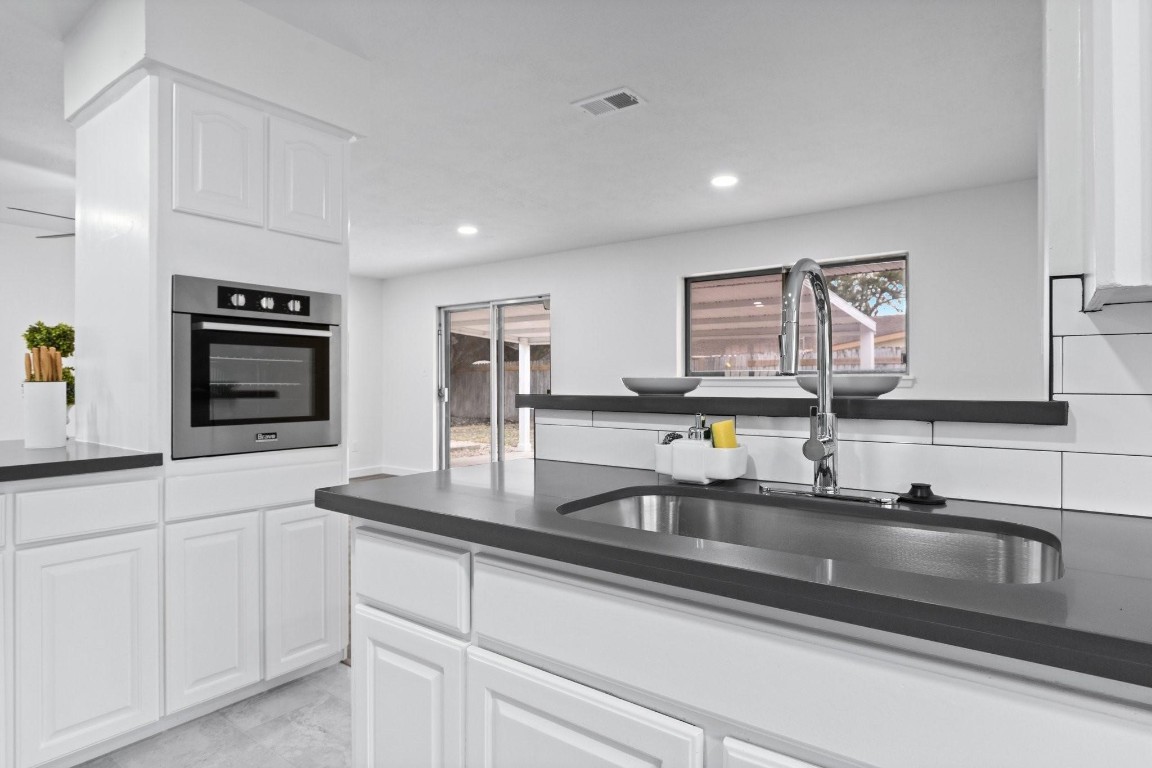 322 East Edgebrook Drive Houston, TX 77034 - Photo 9 of 38 a kitchen with kitchen island a sink stainless steel appliances and counter top