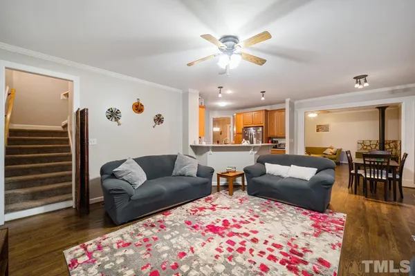 a living room with furniture and a dining table with wooden floor