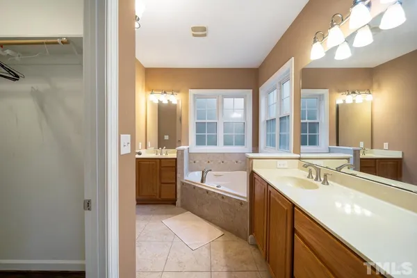 a bathroom with a tub sink and mirror