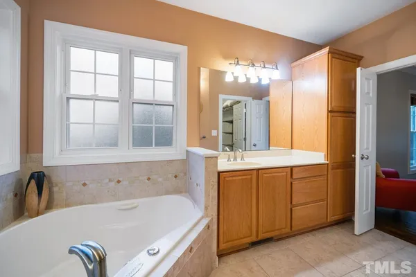 a bathroom with a granite countertop sink a mirror and a bathtub