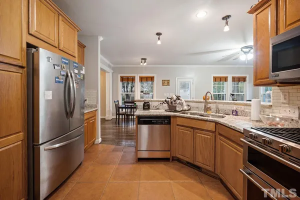 a kitchen with stainless steel appliances a refrigerator sink and microwave