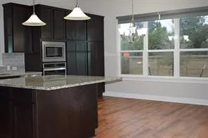 a kitchen with stainless steel appliances granite countertop a stove a sink and a microwave