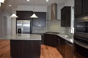 a kitchen with stainless steel appliances granite countertop a sink a microwave a refrigerator and a granite counter tops