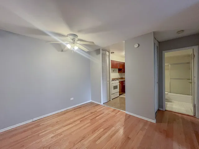 a view of a room with wooden floor and a ceiling fan
