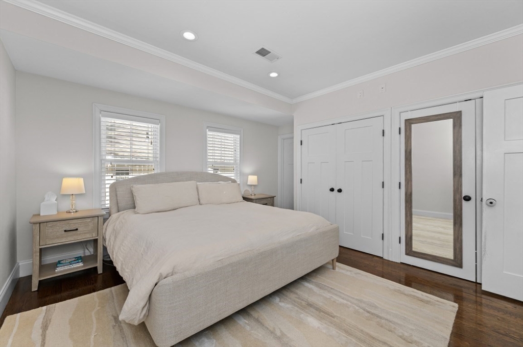 72-74 Manthorne Road, Unit 74 Boston, MA 02132 - Photo 11 of 22 a bedroom with a large bed and wooden floor