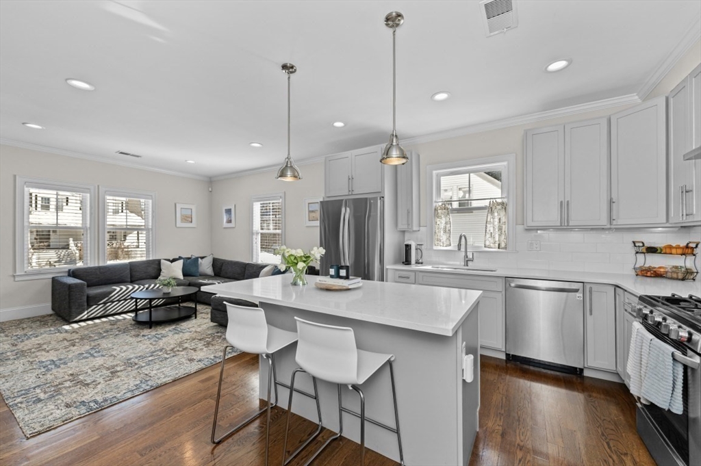 72-74 Manthorne Road, Unit 74 Boston, MA 02132 - Photo 7 of 22 a large kitchen with kitchen island a large counter top space appliances and a living room view