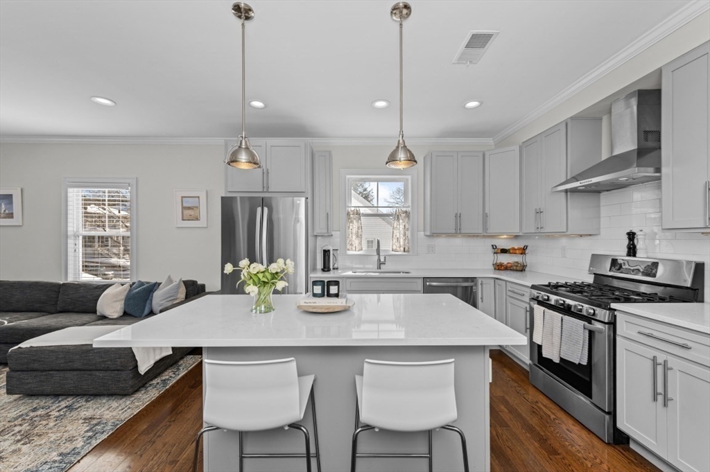 72-74 Manthorne Road, Unit 74 Boston, MA 02132 - Photo 8 of 22 a kitchen with stainless steel appliances granite countertop a stove a sink a kitchen island with a dining table and chairs
