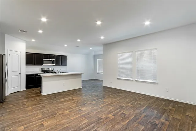 a large kitchen with stainless steel appliances kitchen island a large counter top and a stove top oven