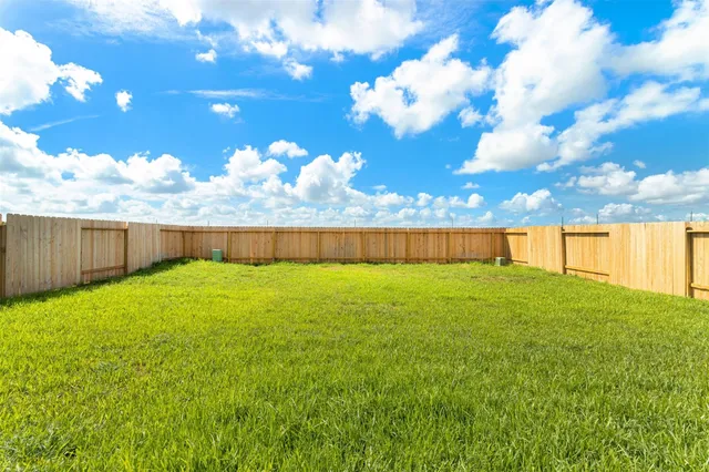 a view of yard with swimming pool and wooden fence