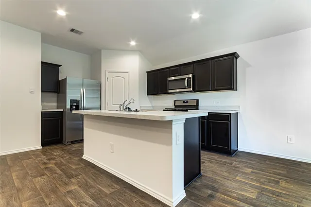 a kitchen with kitchen island a sink stainless steel appliances and cabinets