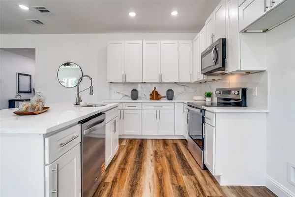 a kitchen with cabinets a sink and appliances