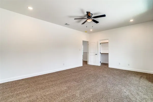 an empty room with closet and windows