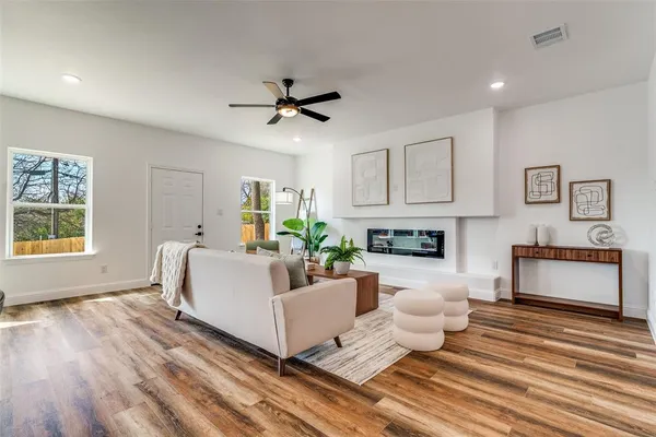 a living room with fireplace furniture and a wooden floor