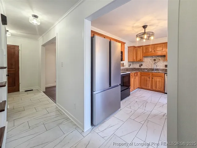 a kitchen with stainless steel appliances granite countertop a refrigerator and a sink