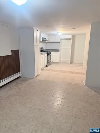 a view of empty room with a kitchen
