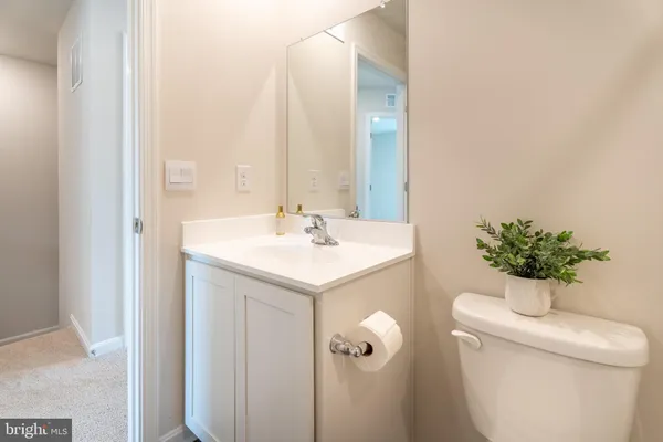 a bathroom with a sink and mirror with toilet