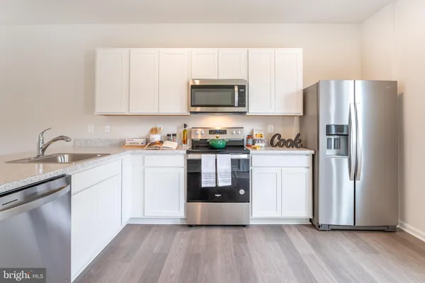 a kitchen with stainless steel appliances a refrigerator sink and microwave