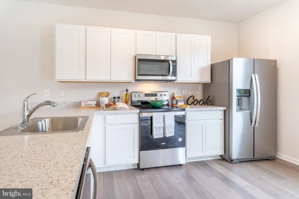 a kitchen with a refrigerator sink and cabinets