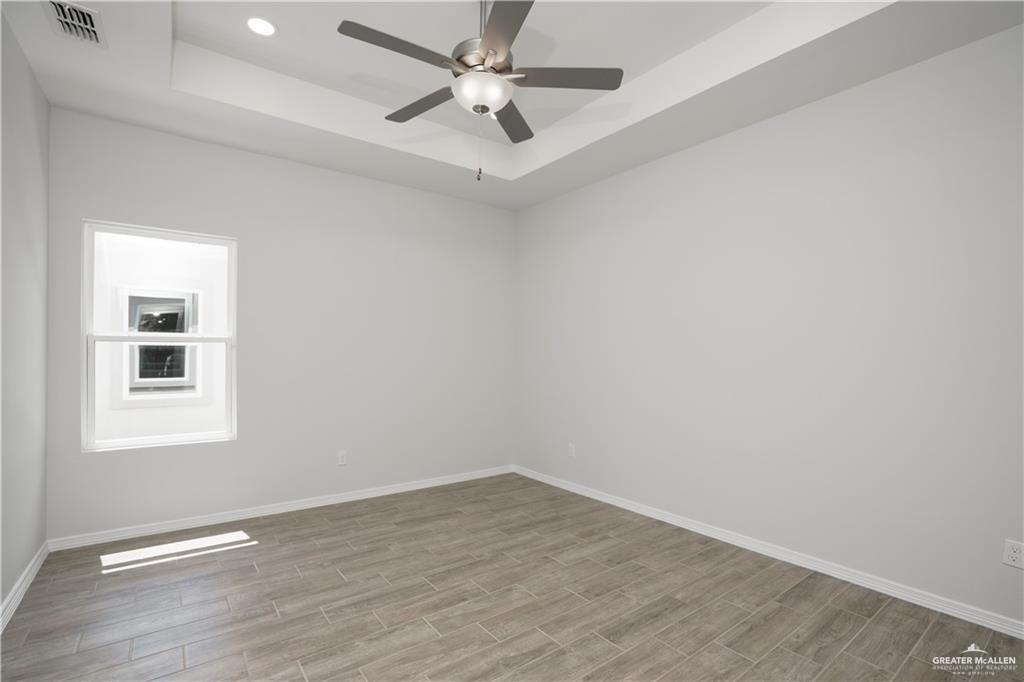 5900 Puffin Avenue, Unit 2 Mission, TX 78573 - Photo 15 of 32 wooden floor in an empty room with a window