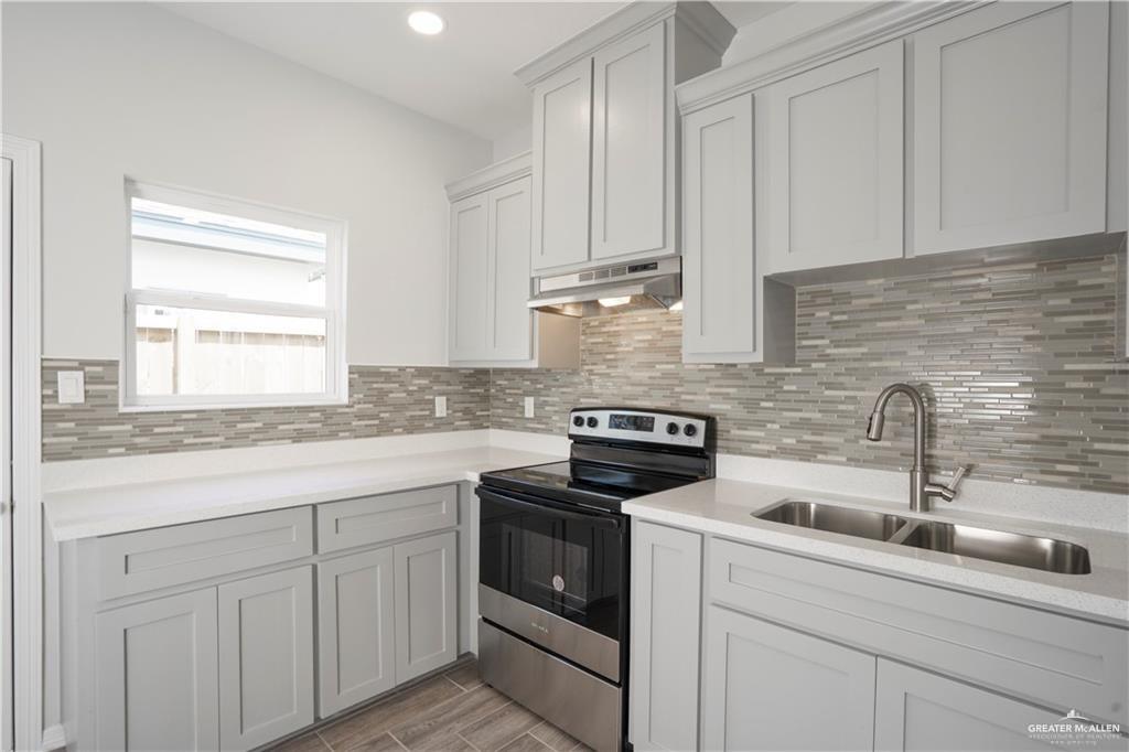 5900 Puffin Avenue, Unit 2 Mission, TX 78573 - Photo 3 of 32 a kitchen with white cabinets and white appliances