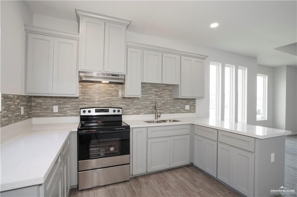 5900 Puffin Avenue, Unit 2 Mission, TX 78573 - Photo 4 of 32 a kitchen with granite countertop white cabinets and white appliances