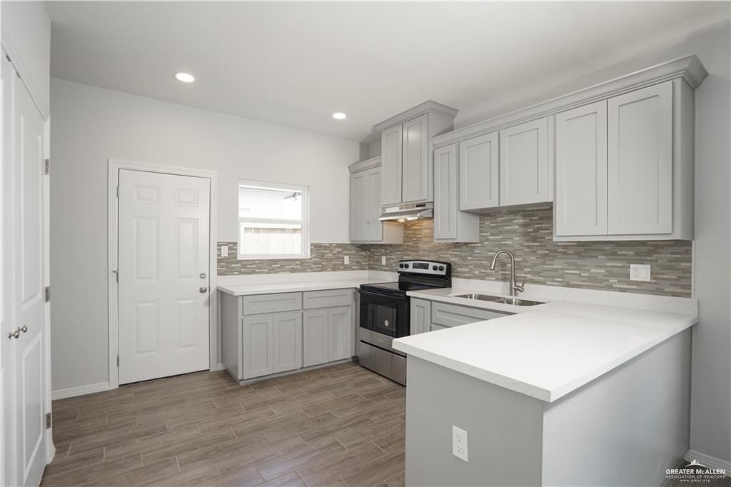 5900 Puffin Avenue, Unit 2 Mission, TX 78573 - Photo 6 of 32 a kitchen with a sink stove and cabinets