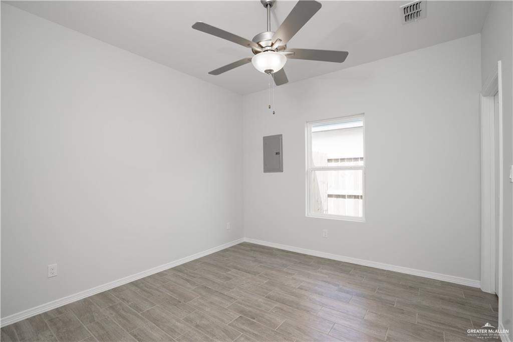 5900 Puffin Avenue, Unit 2 Mission, TX 78573 - Photo 10 of 32 an empty room with wooden floor chandelier fan and windows