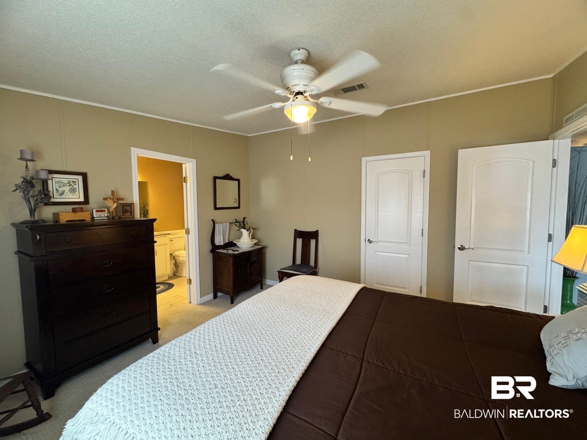 1165 Santa Anna Lane Lillian, AL 36549 - Photo 12 of 43 Bedroom featuring a textured ceiling, a ceiling fan, visible vents, and light colored carpet