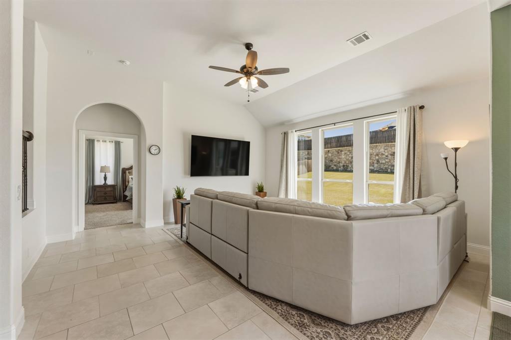 1030 Timber Ridge Drive Justin, TX 76247 - Photo 15 of 40 Living room with ceiling fan, vaulted ceiling, arched walkways, and light tile patterned flooring