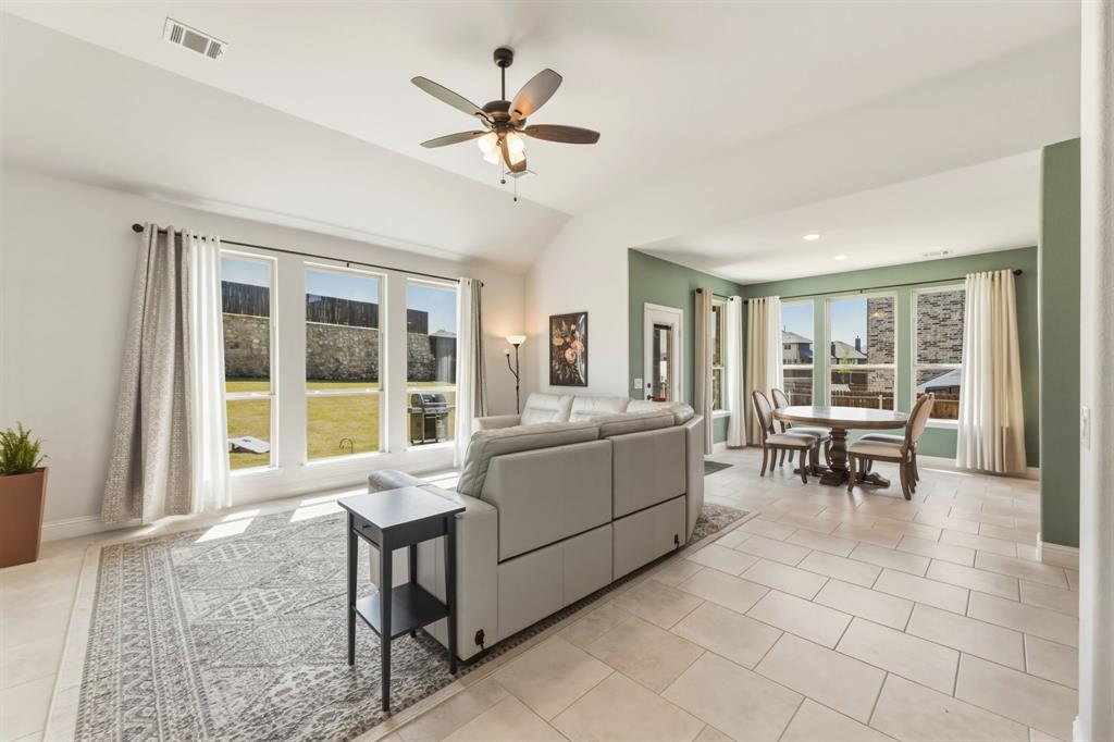 1030 Timber Ridge Drive Justin, TX 76247 - Photo 16 of 40 Living room featuring a ceiling fan, lofted ceiling, and light tile patterned floors