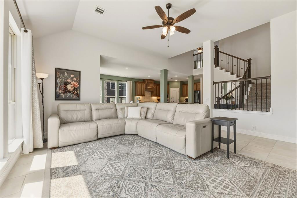 1030 Timber Ridge Drive Justin, TX 76247 - Photo 17 of 40 Living room with ceiling fan, light tile patterned floors, and vaulted ceiling