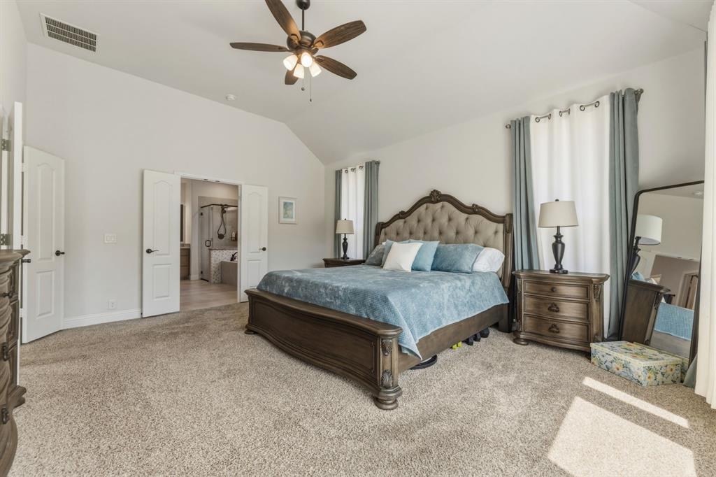 1030 Timber Ridge Drive Justin, TX 76247 - Photo 19 of 40 Bedroom with light colored carpet, lofted ceiling, a ceiling fan, and connected bathroom