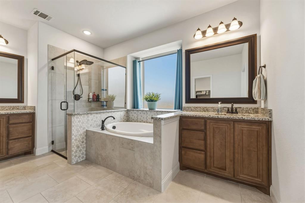 1030 Timber Ridge Drive Justin, TX 76247 - Photo 21 of 40 Bathroom featuring two vanities, a stall shower, a garden tub, and light tile patterned floors