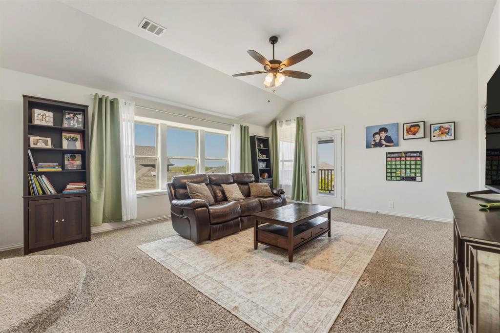 1030 Timber Ridge Drive Justin, TX 76247 - Photo 24 of 40 Carpeted living room with vaulted ceiling and a ceiling fan