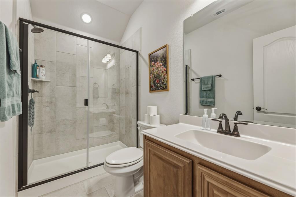 1030 Timber Ridge Drive Justin, TX 76247 - Photo 32 of 40 Full bathroom featuring vanity, a stall shower, and vaulted ceiling
