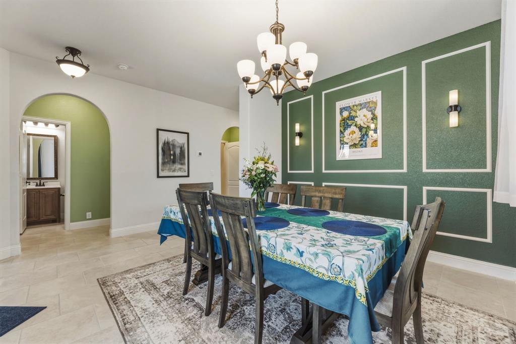 1030 Timber Ridge Drive Justin, TX 76247 - Photo 4 of 40 Dining space with a decorative wall, an accent wall, arched walkways, and hanging lights